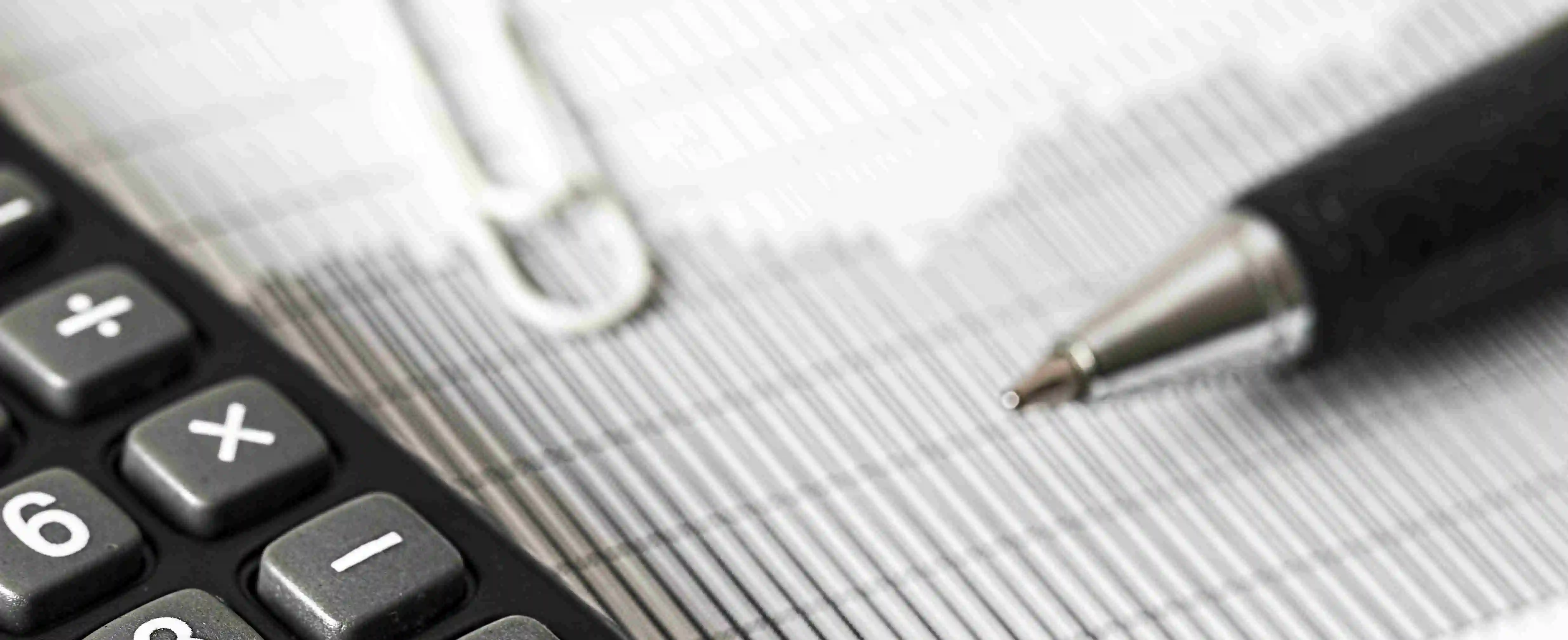 Pen tip and Calculator on a paper 