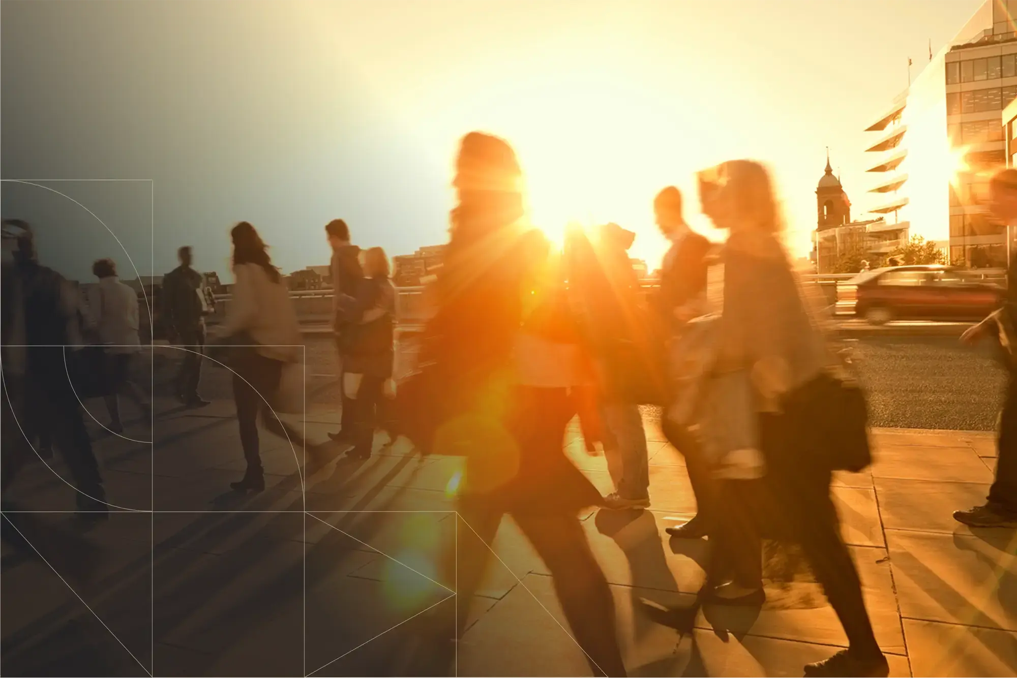 Silhouettes of several people walking across a city bridge or street during sunset, with strong golden sunlight and lens flare shining toward the camera. The pedestrians appear slightly blurred from motion, and buildings—including a modern office building and a tower with a dome—are visible in the background. Thin geometric overlay lines are faintly visible on the left side of the image.