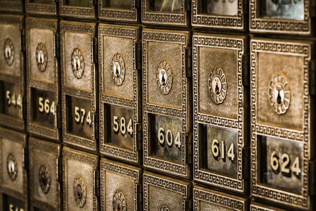Close-up view of vintage brass post office mailboxes with numbered doors and ornate keyholes.